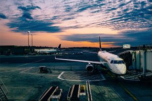 Photo of airport with passenger loading arm extended to passenger jet